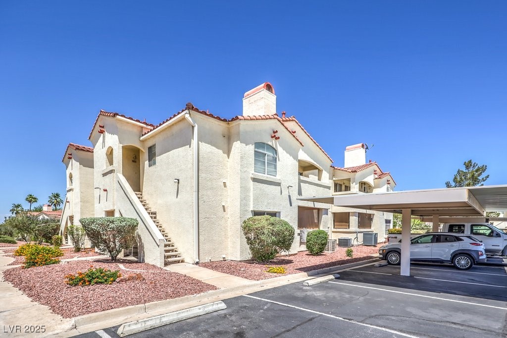 698 South Racetrack Road, Unit 1014 Henderson, NV 89015 - Photo 1 of 25 View of property with covered and uncovered parking, stairway, and cooling unit