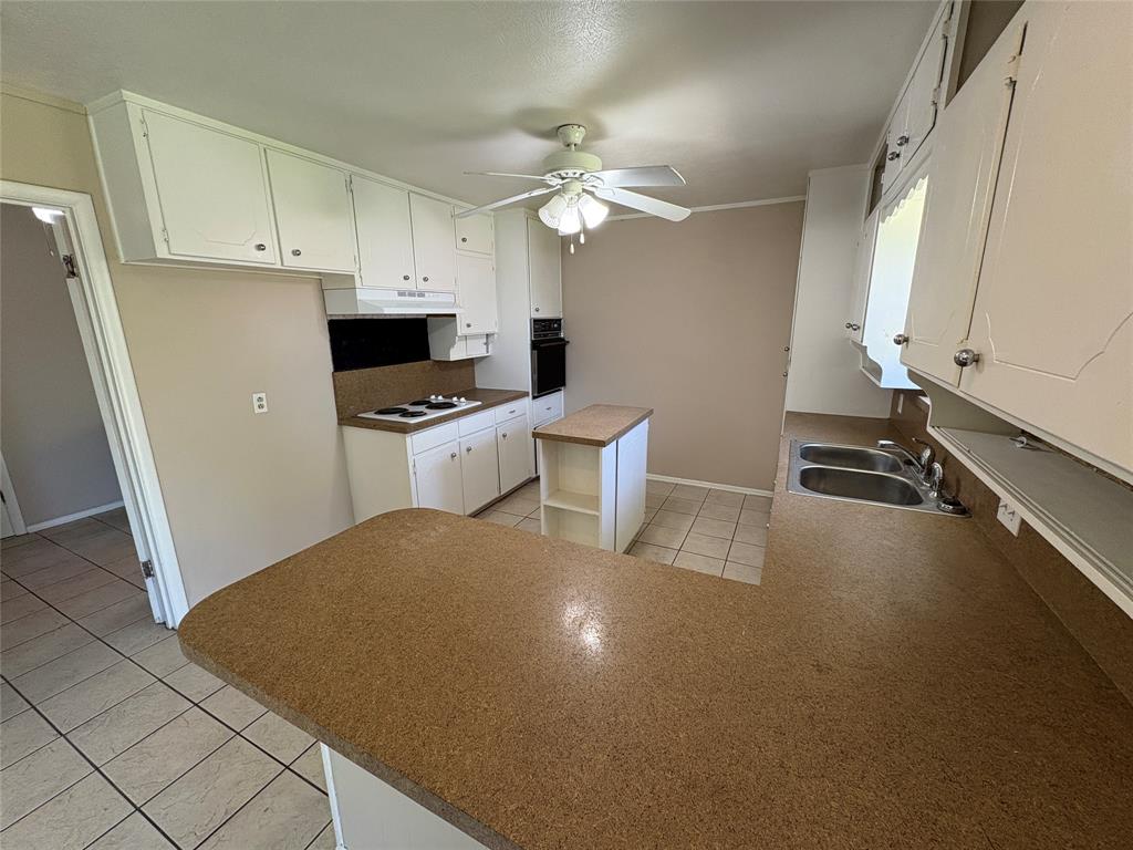 1111 Duane Street Benbrook, TX 76126 - Photo 11 of 28 a kitchen with a refrigerator a stove top oven a sink and dishwasher