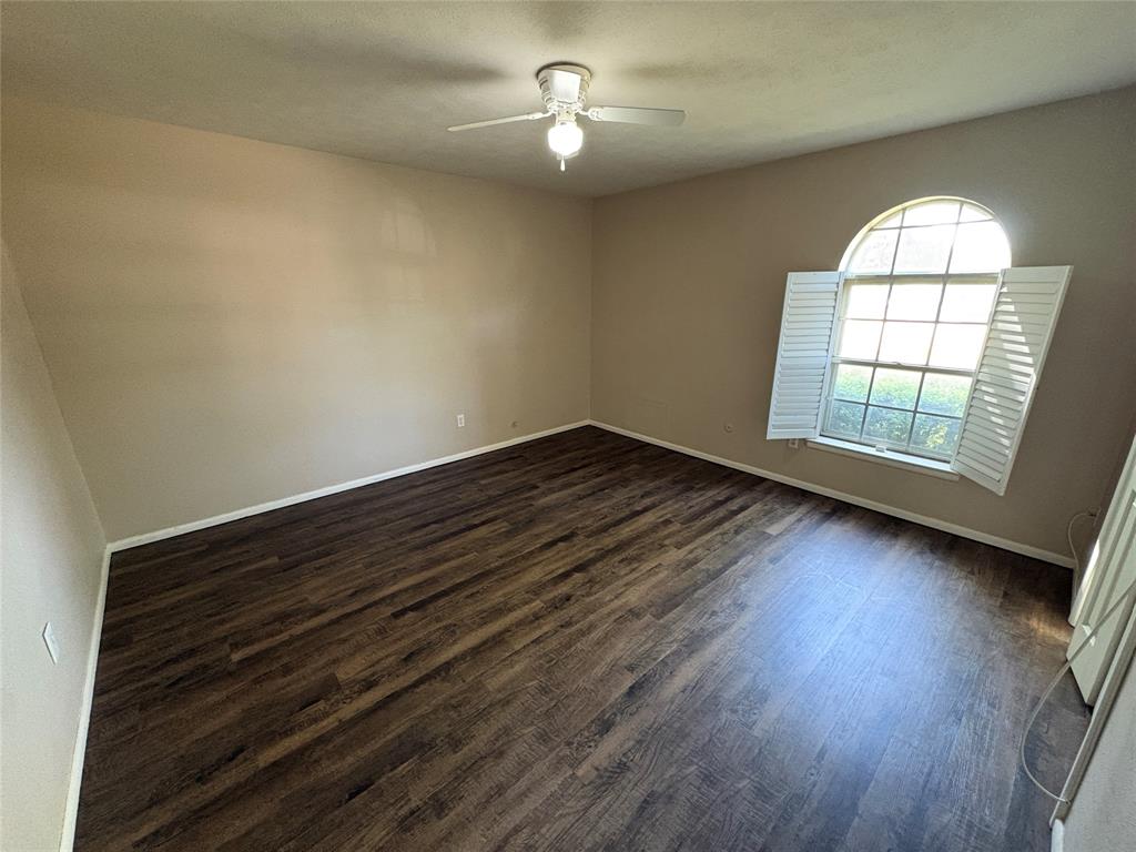 1111 Duane Street Benbrook, TX 76126 - Photo 24 of 28 an empty room with wooden floor chandelier fan and windows