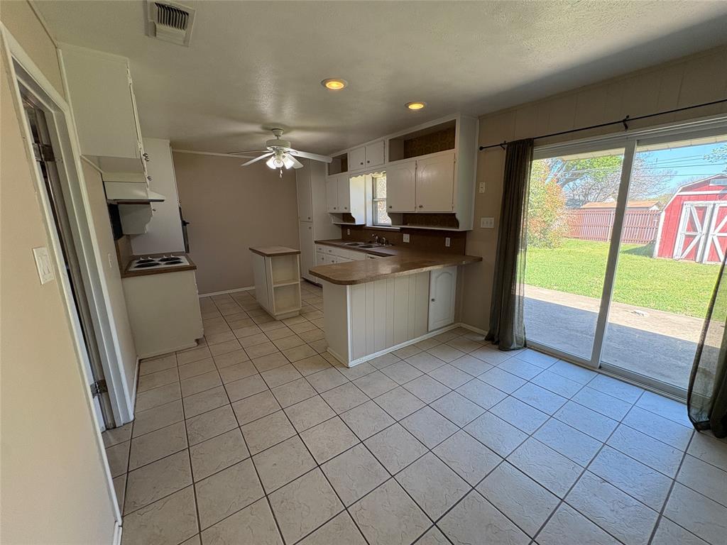 1111 Duane Street Benbrook, TX 76126 - Photo 9 of 28 a kitchen with stainless steel appliances a sink and a refrigerator