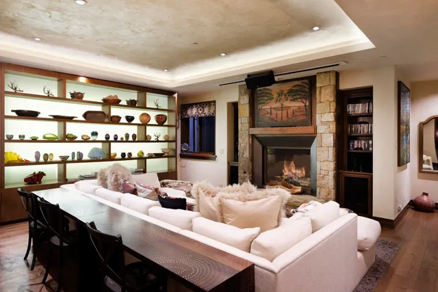 a bedroom with a bed a chandelier and flat screen tv