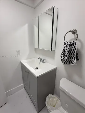 a bathroom with a sink mirror vanity and toilet