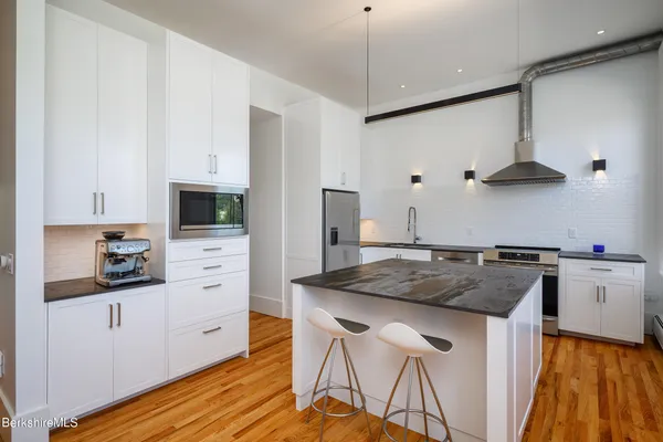 a kitchen with stainless steel appliances granite countertop a stove and a refrigerator