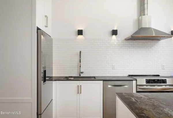 a kitchen with stainless steel appliances granite countertop a sink and a stove