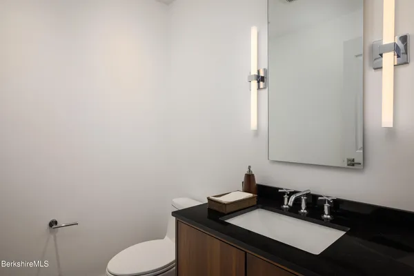 a bathroom with a sink toilet and mirror