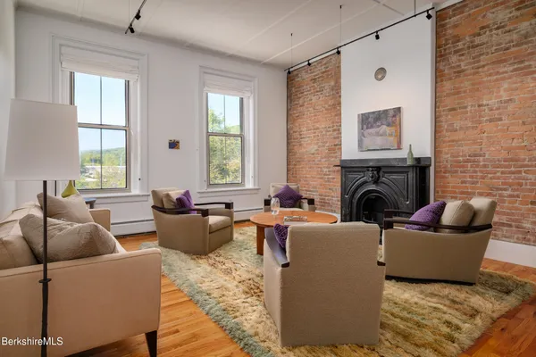 a living room with furniture a large window and a fireplace