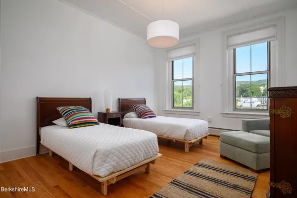 a bedroom with two beds and a large window