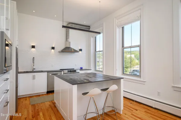 a kitchen with stainless steel appliances granite countertop a sink a stove and a refrigerator