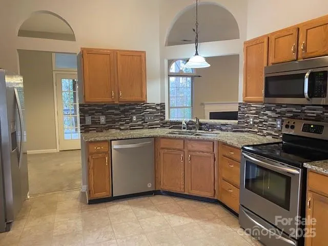a kitchen with stainless steel appliances granite countertop a stove a sink and a microwave