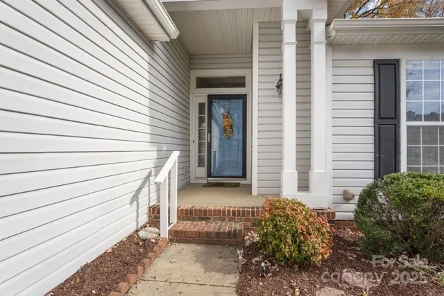 a view of a house with a door and wooden bench