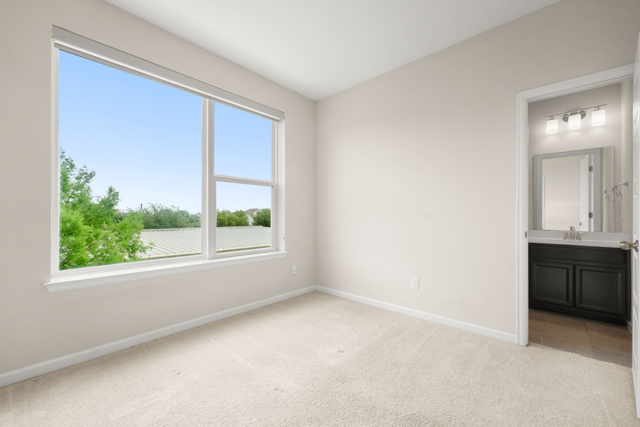 4403 Swift Path Austin, TX 78741 - Photo 19 of 32 Bright room featuring a large window, neutral carpet, and light-colored walls