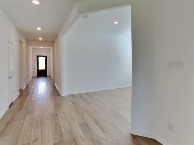 a view of a hallway with wooden floor