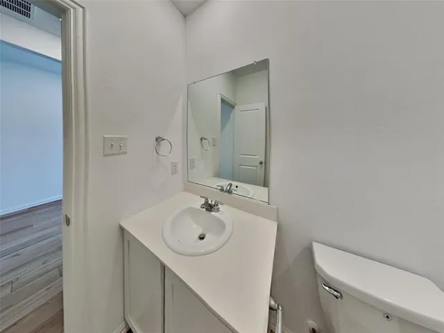 a bathroom with a sink and mirror with toilet