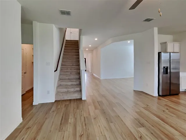 a view of a hallway with wooden floor and staircase