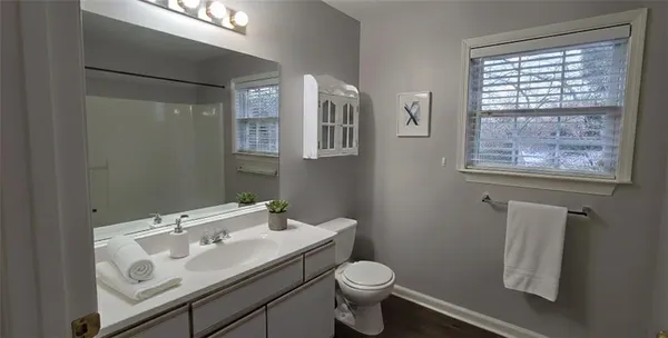 a bathroom with a sink toilet and a mirror