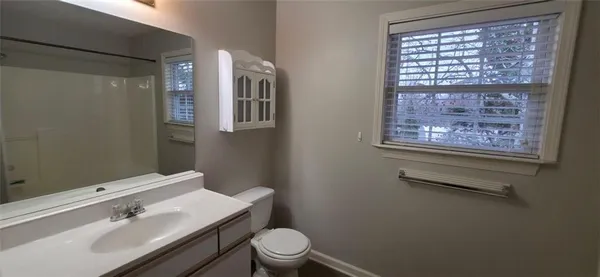 a bathroom with a sink mirror vanity and toilet