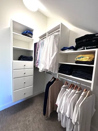 a view of walk in closet with clothes and shoes