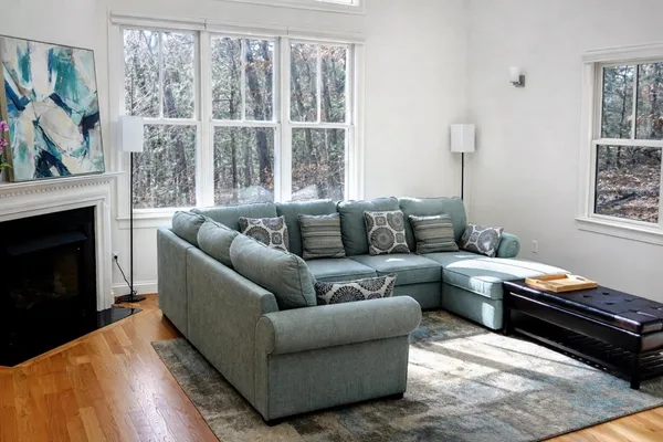 a living room with furniture fireplace and a window