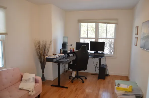 a view of a workspace with furniture and a window