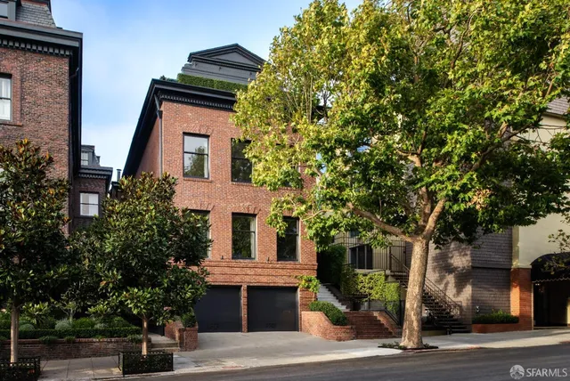 a front view of a house with a tree