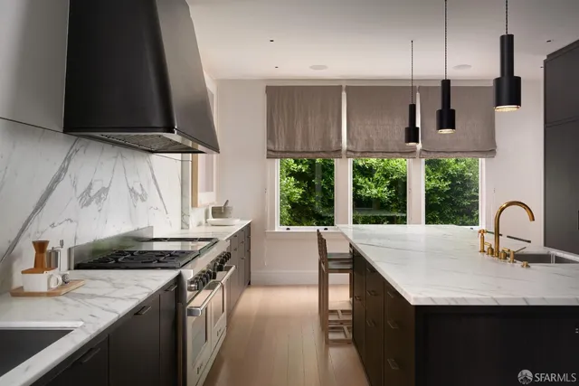a kitchen with stainless steel appliances granite countertop a sink a stove and a wooden cabinets