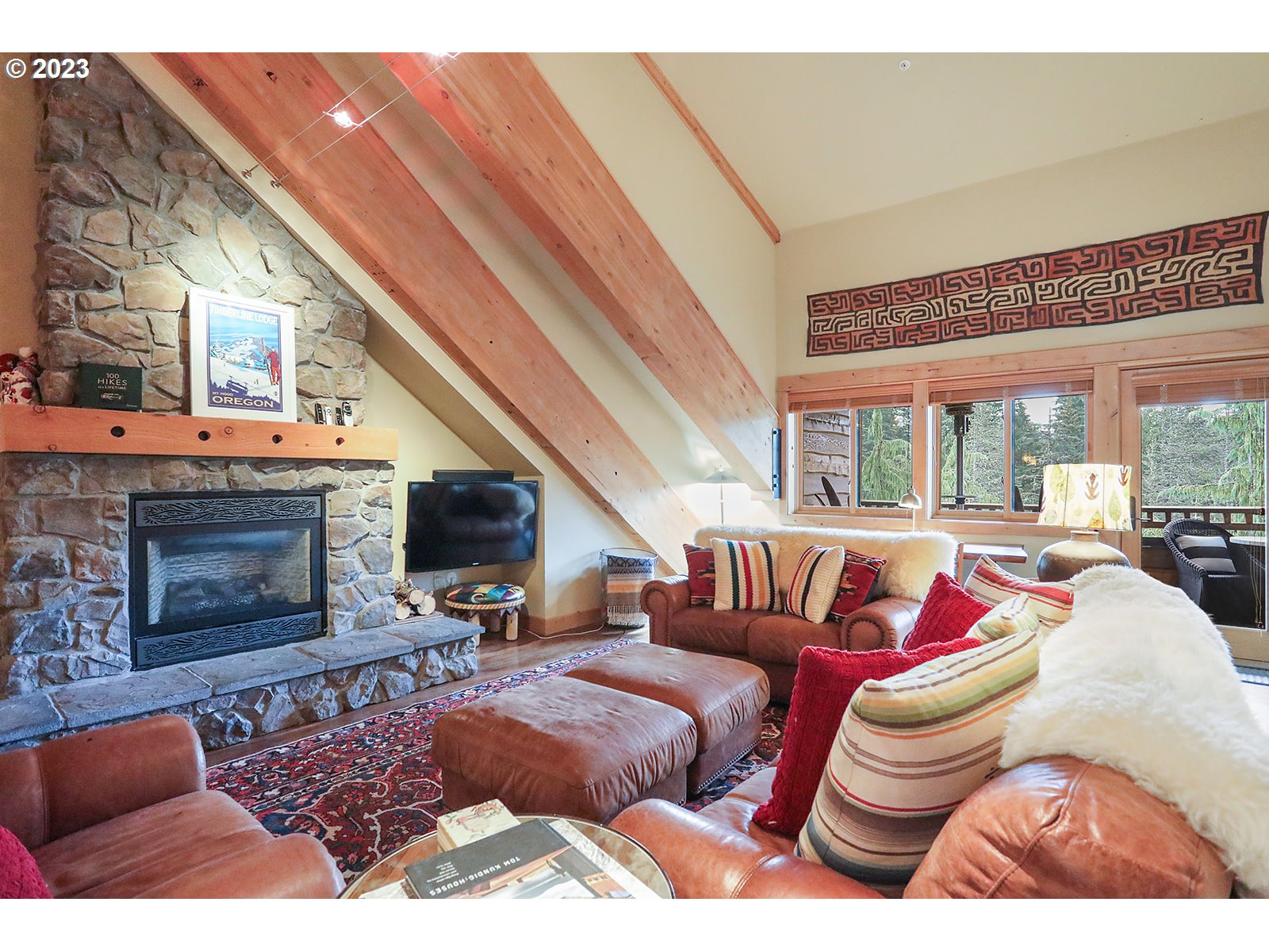 31226 East Collins Lake Road, Unit 27 Government Camp, OR 97028 - Photo 12 of 48 a living room with furniture a fireplace and a flat screen tv