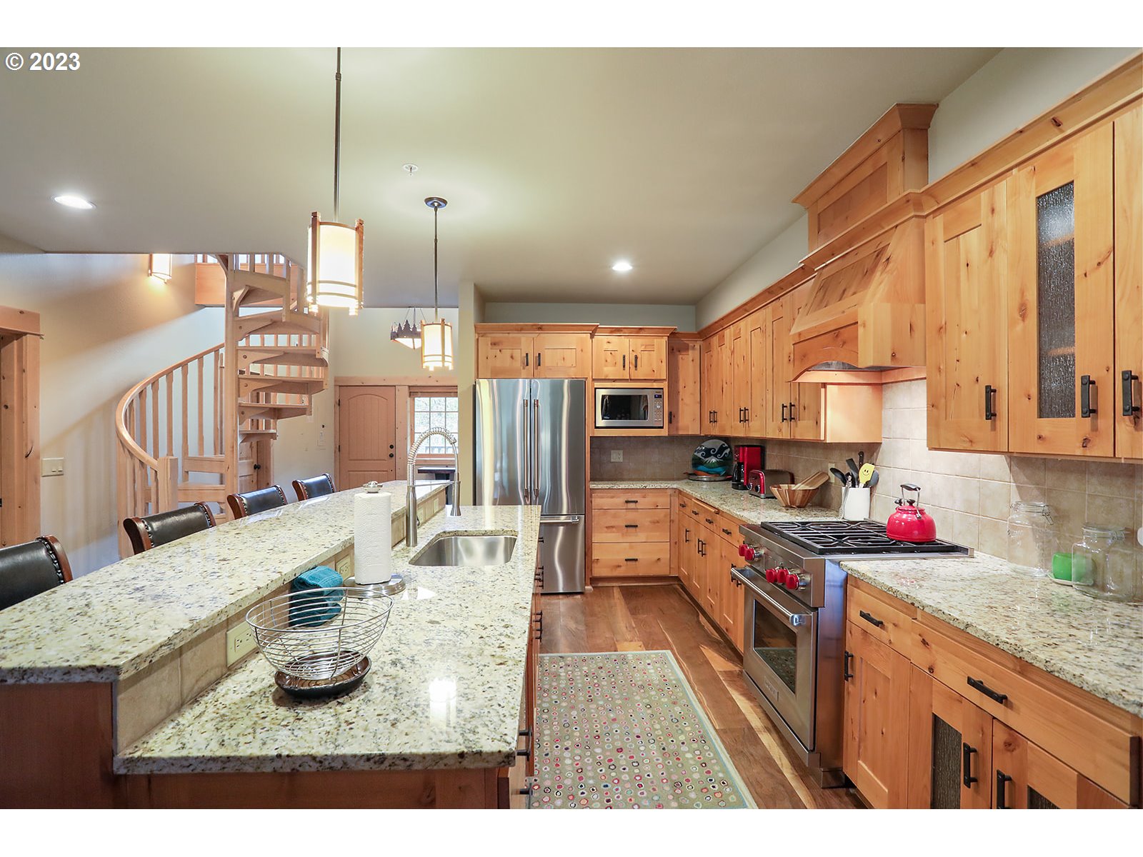 31226 East Collins Lake Road, Unit 27 Government Camp, OR 97028 - Photo 4 of 48 a kitchen with stainless steel appliances kitchen island granite countertop a sink a stove and a wooden cabinets
