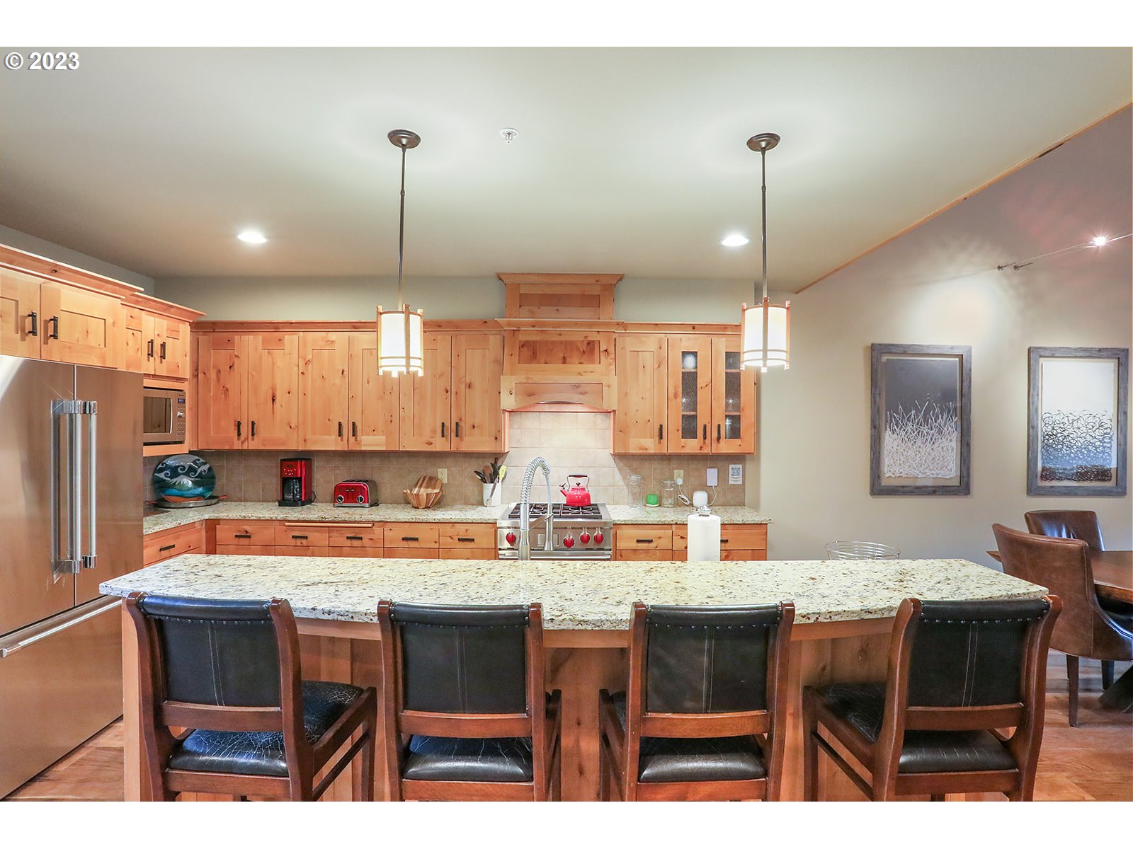 31226 East Collins Lake Road, Unit 27 Government Camp, OR 97028 - Photo 6 of 48 a kitchen with stainless steel appliances kitchen island granite countertop a dining table chairs and white cabinets