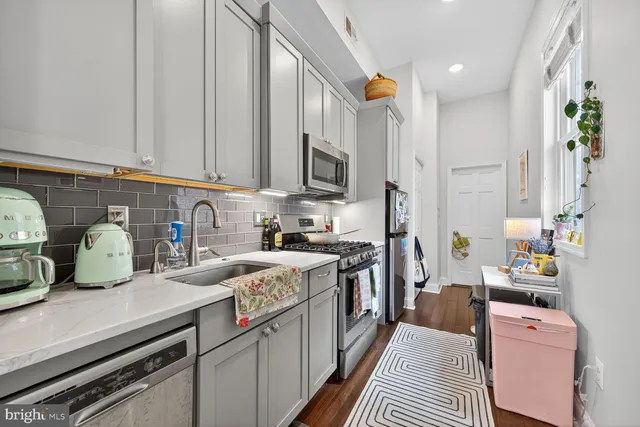 a kitchen with stainless steel appliances granite countertop a stove a sink dishwasher and cabinets with wooden floor