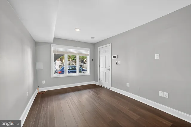 a view of a kitchen with wooden floor and a window