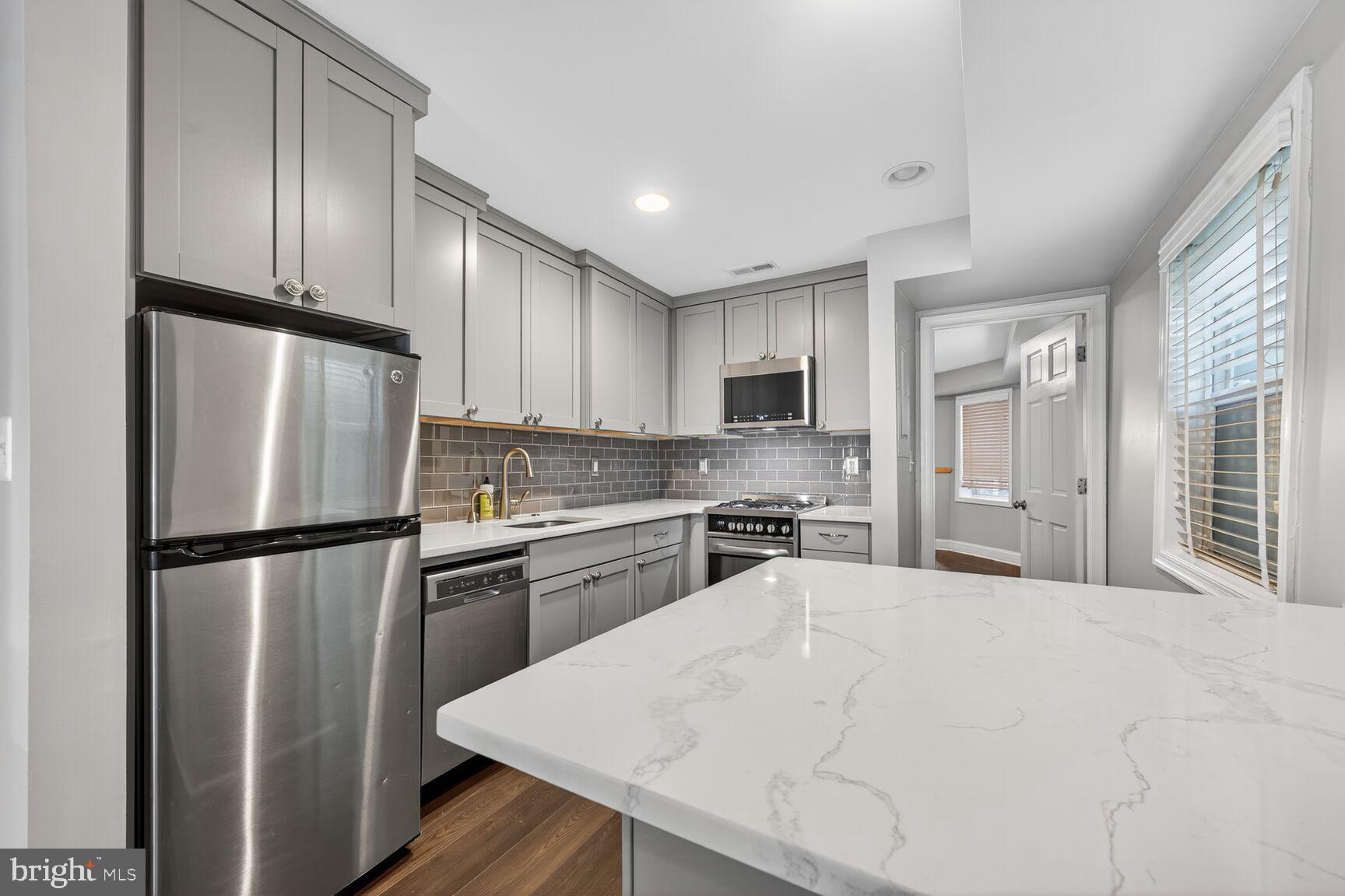 1409 Hopkins Street Northwest Washington, DC 20036 - Photo 6 of 44 a kitchen with stainless steel appliances a refrigerator sink and cabinets