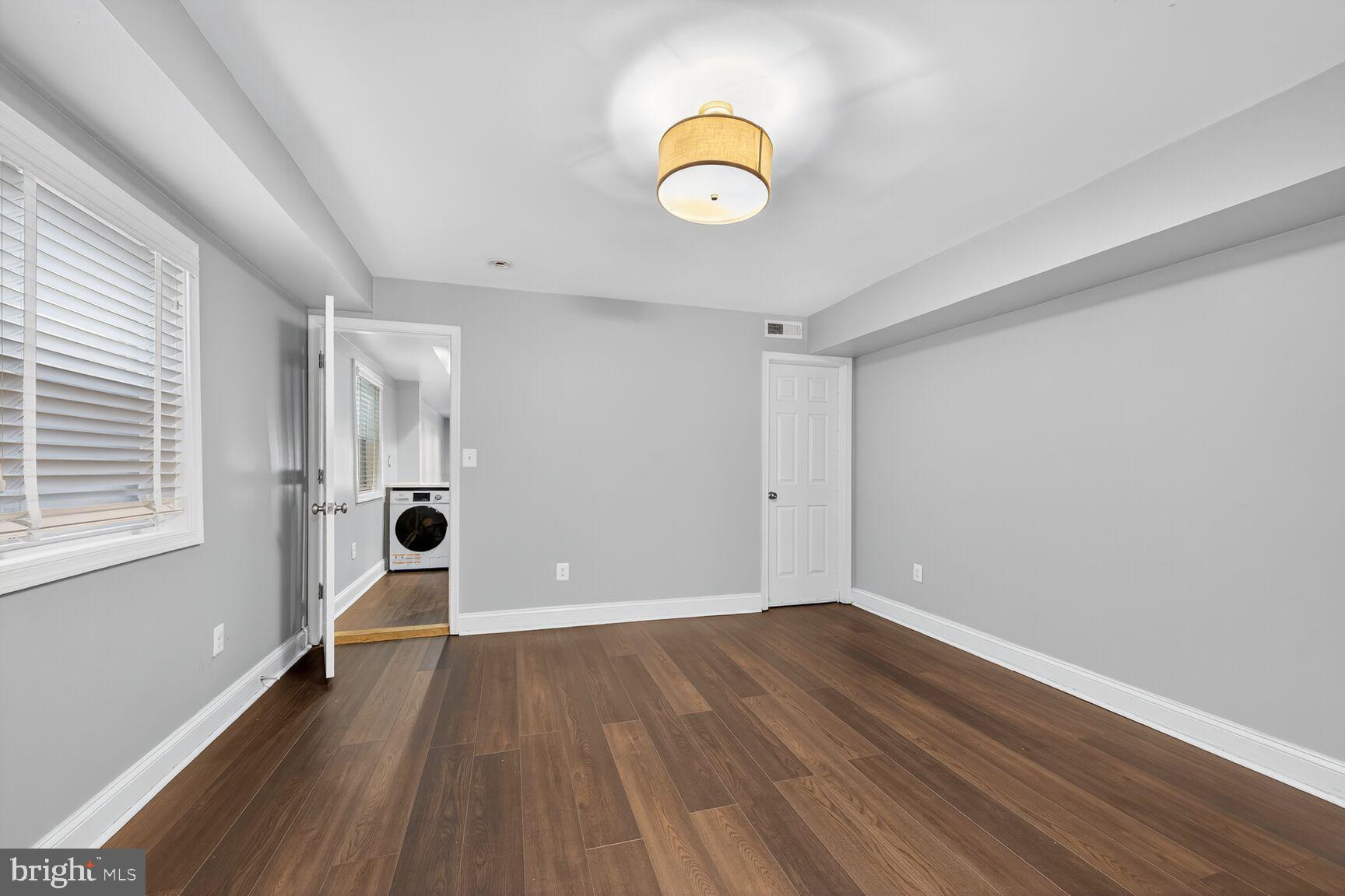 1409 Hopkins Street Northwest Washington, DC 20036 - Photo 10 of 44 an empty room with wooden floor and windows