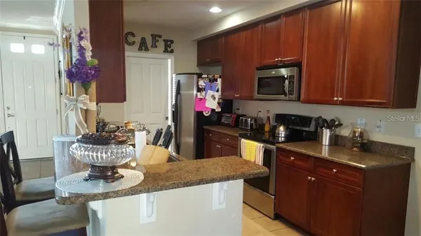 a kitchen with a refrigerator and a stove top oven