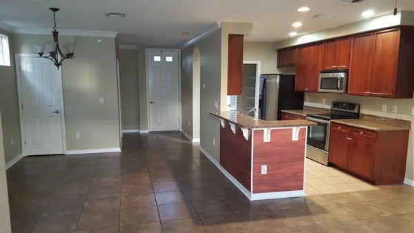 a kitchen with stainless steel appliances granite countertop a refrigerator and a stove top oven