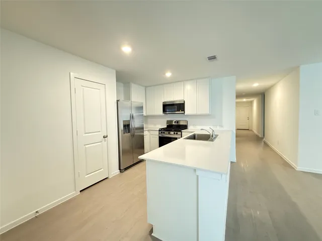 a kitchen with refrigerator cabinets and a sink