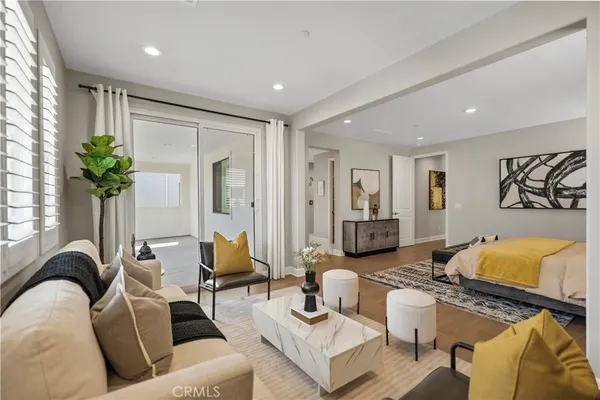a living room with furniture potted plant and wooden floor