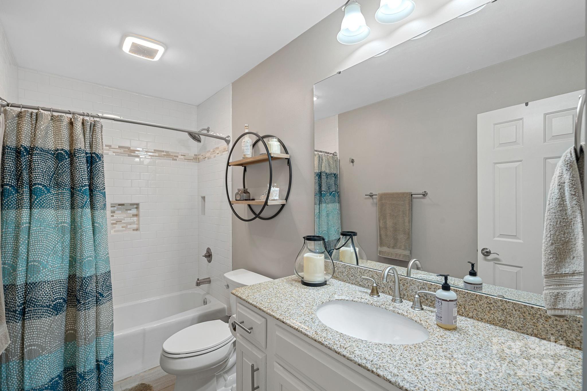 345 Jib Court Davidson, NC 28036 - Photo 20 of 40 a bathroom with a granite countertop sink mirror toilet shower and bathtub