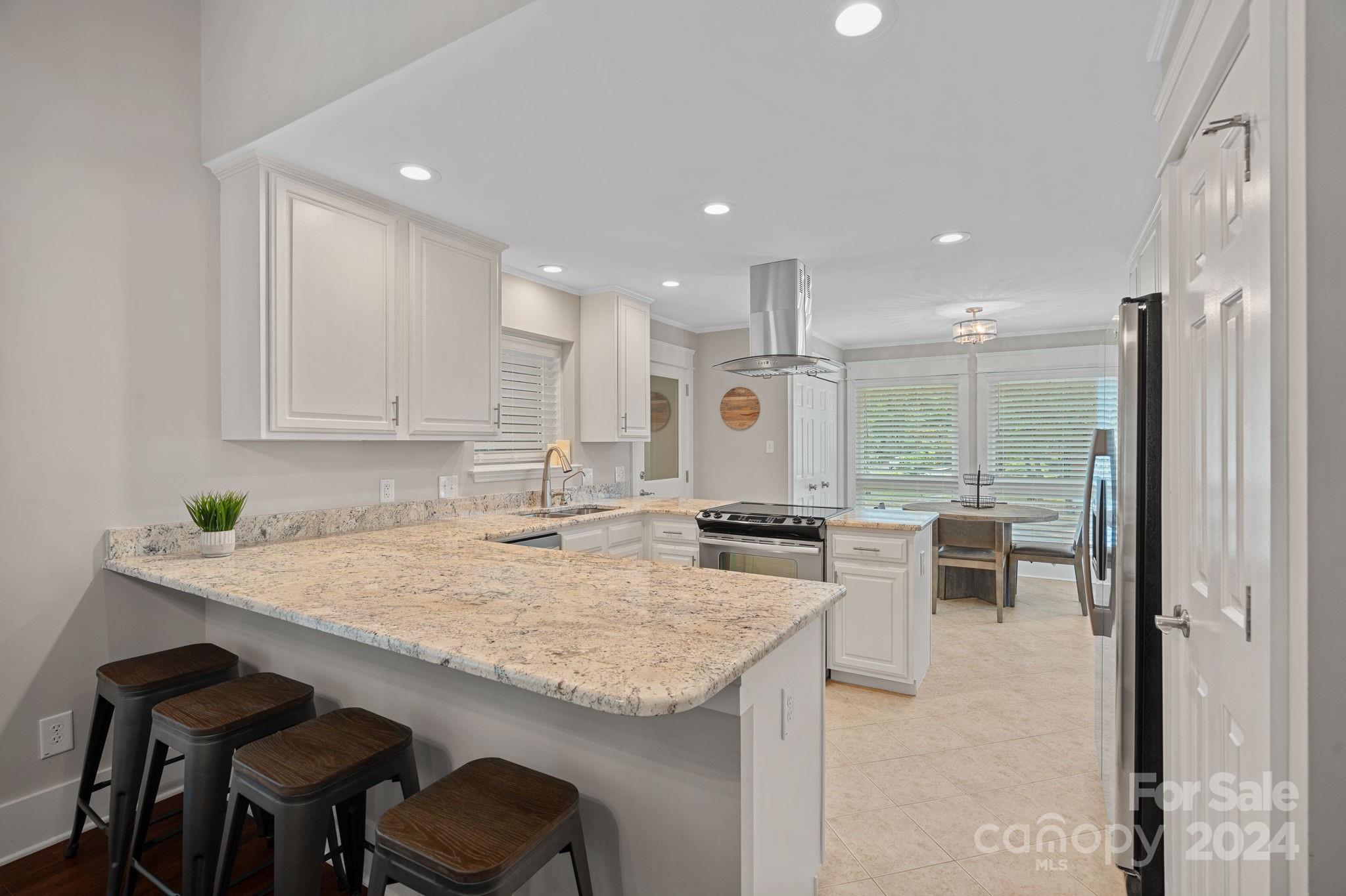 345 Jib Court Davidson, NC 28036 - Photo 10 of 40 a kitchen with granite countertop sink stove and chairs