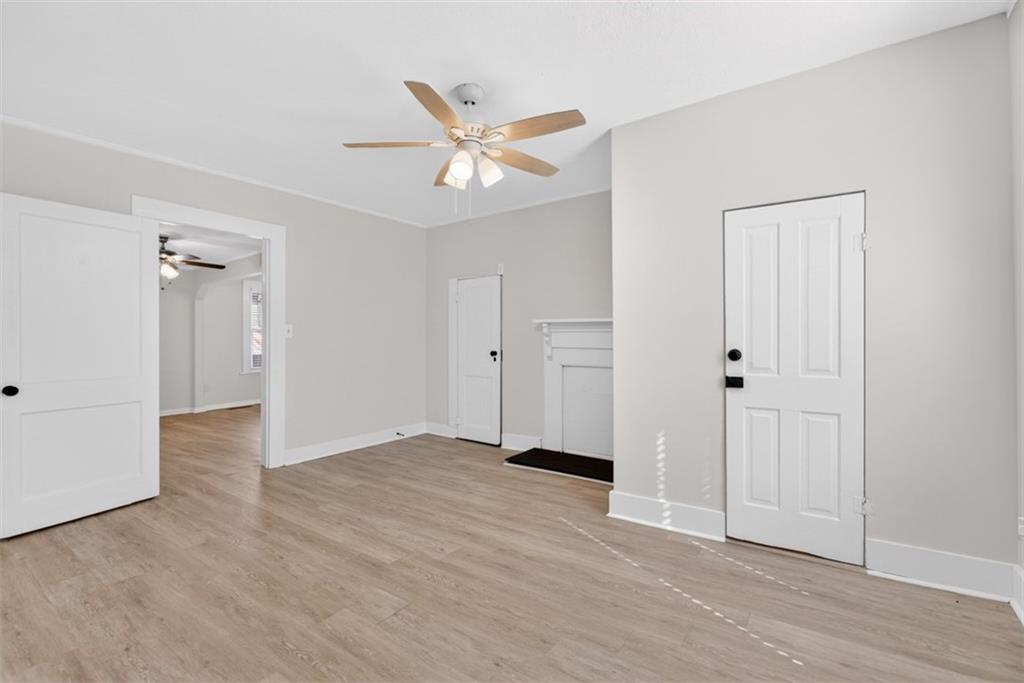 246 Spring Street Commerce, GA 30529 - Photo 10 of 23 an empty room with wooden floor and a ceiling fan