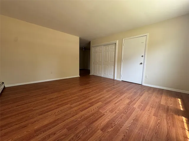 a view of an empty room with wooden floor