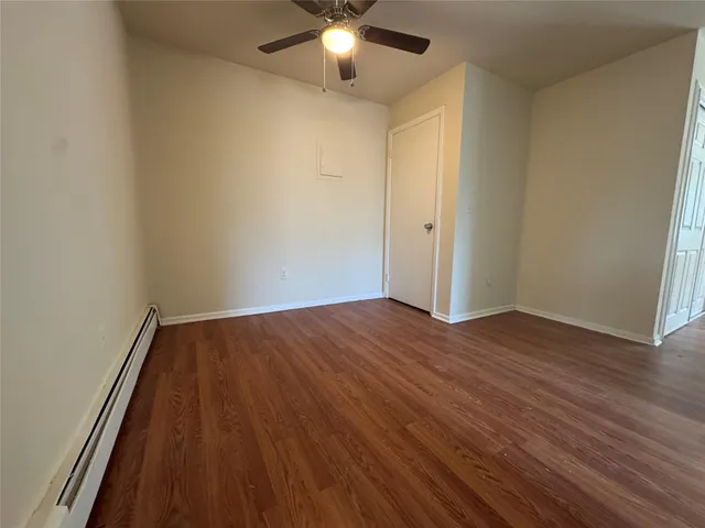 a view of a room with wooden floor and a ceiling fan