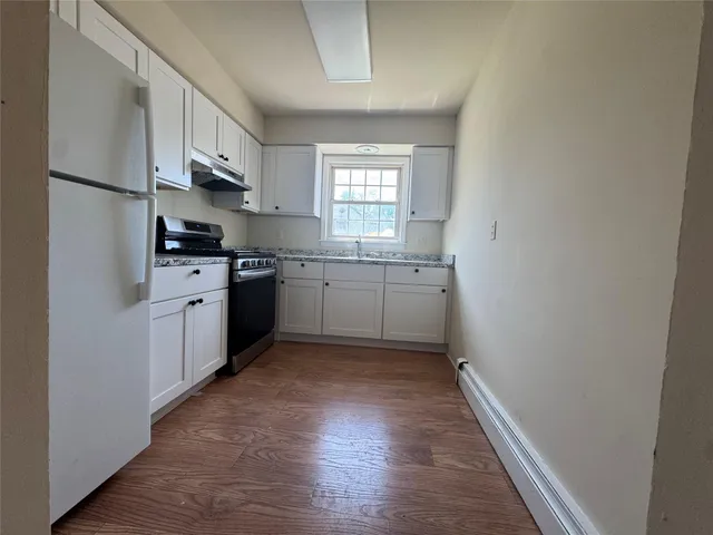 a kitchen with granite countertop white cabinets and white appliances