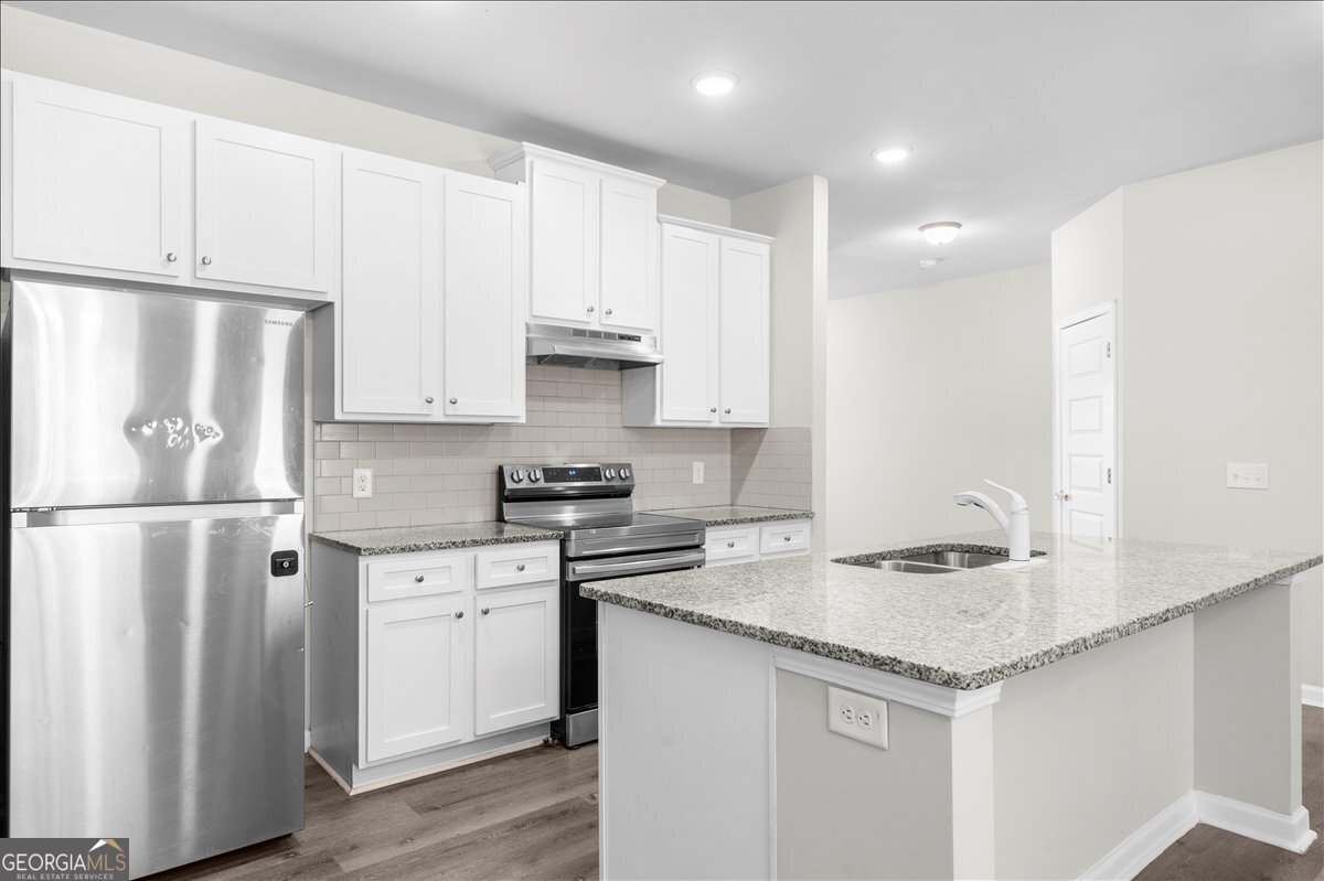 220 Harrison Street Calhoun, GA 30701 - Photo 7 of 17 a kitchen with stainless steel appliances granite countertop a sink stove and refrigerator