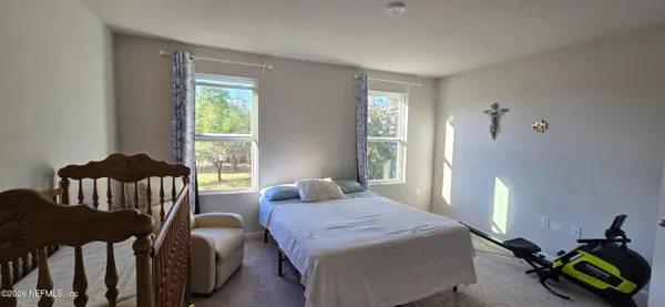 a bedroom with a bed two beds and a window