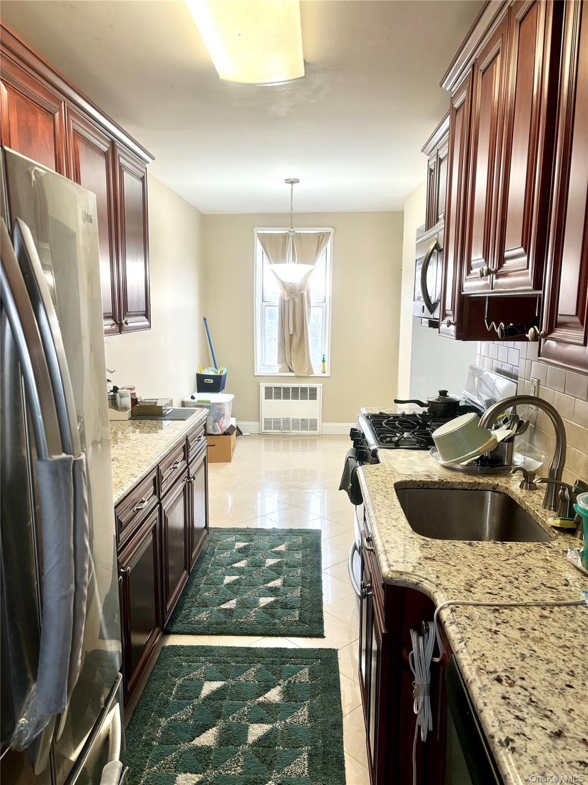 61 Bronx River Road, Unit 7H Yonkers, NY 10704 - Photo 8 of 13 a kitchen with granite countertop stainless steel appliances a sink a stove and a refrigerator