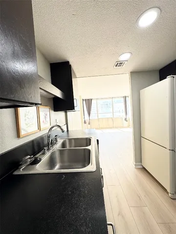 a kitchen with a sink cabinets and a refrigerator