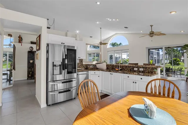 a kitchen with stainless steel appliances kitchen island granite countertop a refrigerator a sink a stove and island