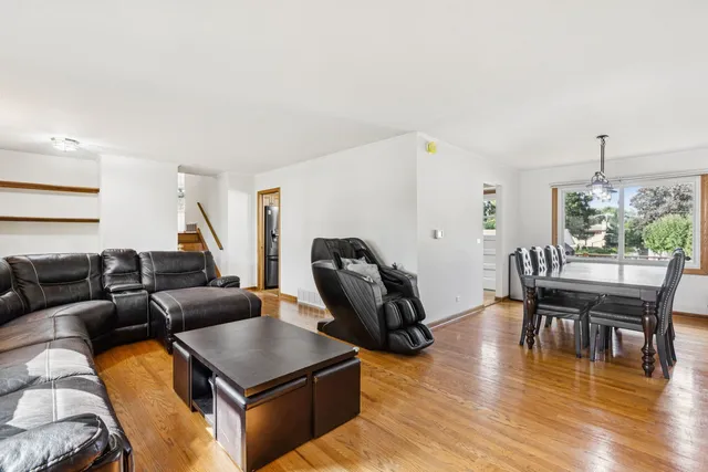 a living room with furniture a dining table and a wooden floor