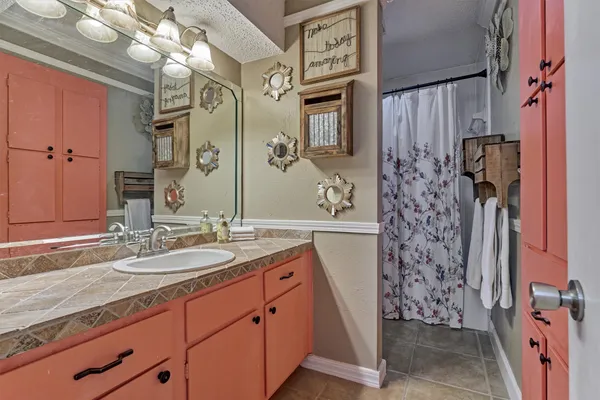 a bathroom with a granite countertop sink a mirror and shower