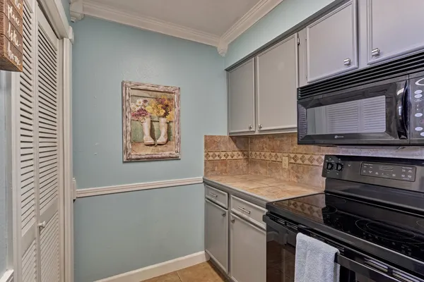 a kitchen with granite countertop a stove and a microwave